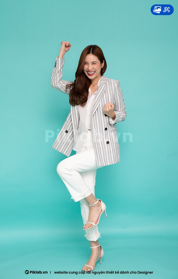 Portrait of an Asian woman standing, posing, determined and smiling, isolated on blue background JPG model người mẫu
